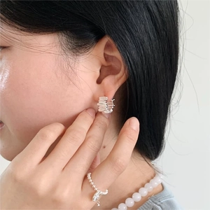 Detail of 925 sterling silver earrings with crushed texture and beaded ring on model