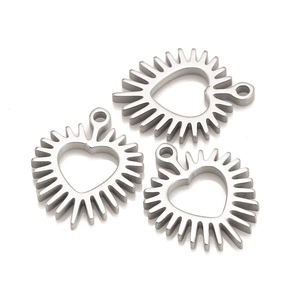 Macro shot of three stainless steel heart pendants with sunburst edges and hanging loops
