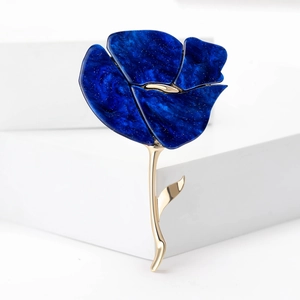 Detail van blauwe hars roos broche met marmertextuur en gouden steel op witte houder