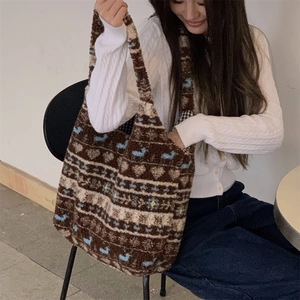 Ethnic plush tote bag with heart patterns shown on a model in a cozy cafe setting