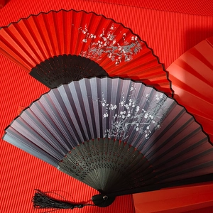Classical Chinese bamboo folding fans with plum blossom patterns and silk tassels