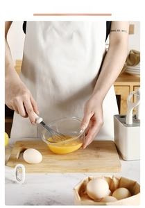 Action shot of a white ergonomic whisk mixing eggs in a modern kitchen setting