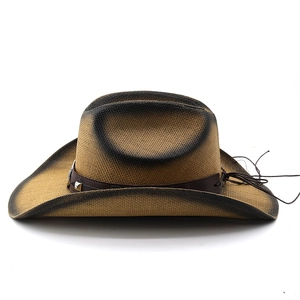 Détail d'un chapeau de cowboy en paille avec ceinture en cuir vintage et rivets en métal