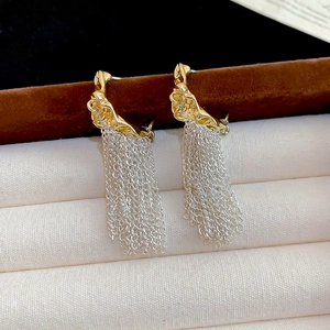 Detail of French vintage C-shaped gold pleated studs with silver fringe tassels