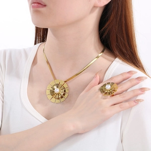 Détail d'un ensemble de bijoux fleur dorée vintage avec perles sur chaîne plate