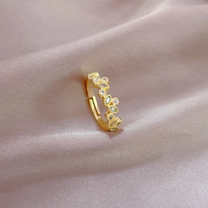 Elegant gold leaf adjustable ring with sparkling zircon stones on soft silk fabric