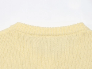 Close-up of cream crewneck sweater showing premium fine knit texture and ribbed neckline