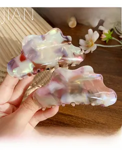 Close-up of acetic acid cloud hair claw clips with iridescent marble texture
