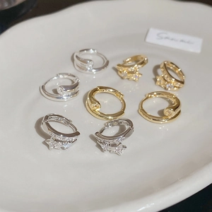 Vue détaillée des boucles d'oreilles créoles étoiles dorées 18 carats avec zircons