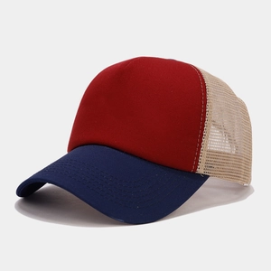 Detail view of red cotton crown and beige mesh panels on a breathable trucker hat