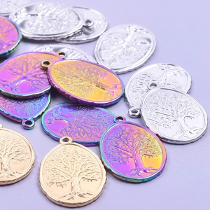Oval stainless steel tree pendants in silver, gold and rainbow finish on a plain background