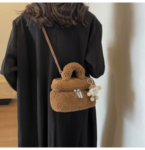 Brown faux fur small square bag with top handle and crossbody strap worn by a model