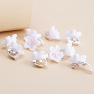 Floral resin ear clips for kids with white petals and pink centers in a bulk set