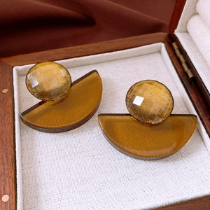 Detail of amber geometric resin earrings with gold foil accents in a jewelry box