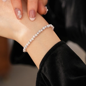 Close-up of pearl and rhinestone bracelet on model with black velvet background