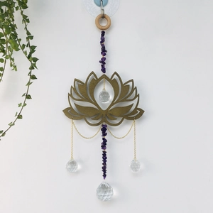 Amethyst suncatcher with golden lotus and crystal balls hanging against a white wall