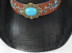 Dettaglio cappello da cowboy nero con pietra turchese e ricami floreali sul cinturino