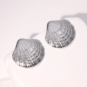 Macro detail of polished stainless steel shell stud earrings on white stone base