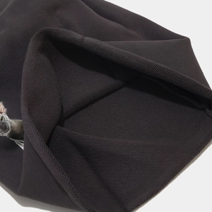 Vue macro détaillée du tissu French Terry marron foncé avec un motif de chat