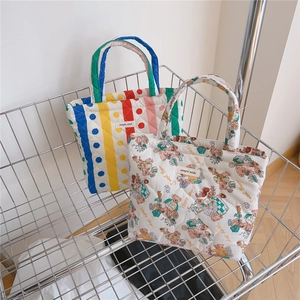 Détail de sacs fourre-tout en coton matelassé avec rayures et imprimés ours mignons
