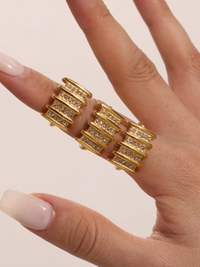Close-up of golden multi-layered rings set with sparkling Czech rhinestones on hand