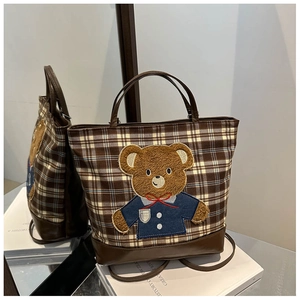 Close-up of brown plaid wool tote bag featuring a cute 3D plush bear embroidery detail