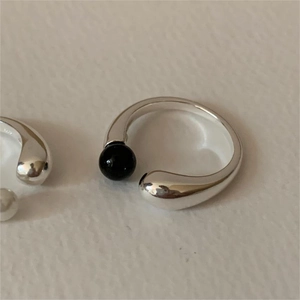 Detailed close-up of 925 silver open ring with a black bead and teardrop end finish