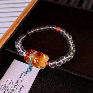 Macro view of crystal beaded bracelet with amber bear pendant in a luxury jewelry box