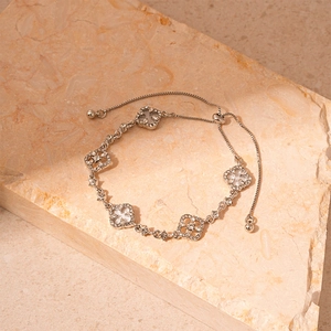 Detail of silver adjustable clover bracelet with sparkling diamonds and white shell