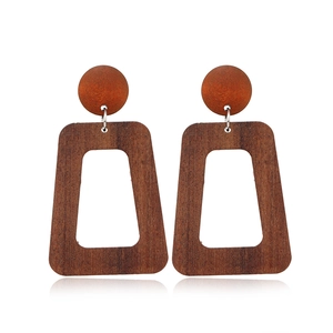 Detailed view of dark brown geometric wooden earrings with round studs and trapezoid drops