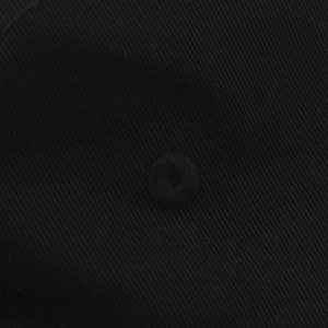 Vista macro de tela de sarga de algodón negro con ojal de ventilación bordado en gorra.