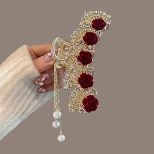 Detail of gold floral hair claw clip with velvet red roses, rhinestones and pearl tassels