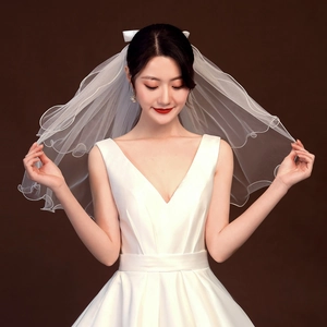 Elegant short white bridal veil with wavy lace edges and tiered tulle for a soft fluffy look