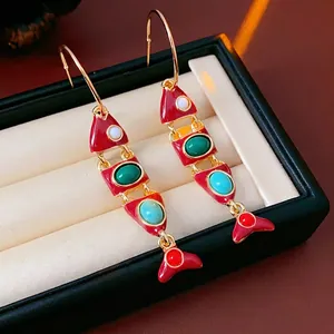Vintage gold-plated fish drop earrings with vibrant red enamel and colorful gemstones