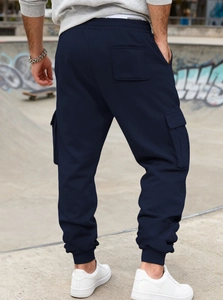 Detail of navy blue cargo pants with multi-pockets and elastic cuffs on male model