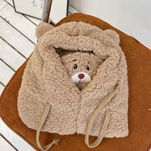 Detail of plush brown bear hat with 3D ears and embroidered facial features on rim