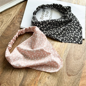 Detailed texture of pink and black floral chiffon headbands on a wooden desk background