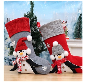 Detail of Christmas stockings with grey and red 3D penguin designs and snowflake accents