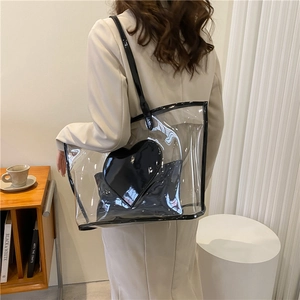 Transparent PVC tote bag with black heart-shaped inner pouch and shoulder strap
