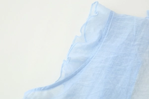 Detailed view of light blue ruffled edges and lightweight chiffon fabric texture