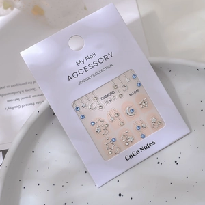 Close-up of star and moon nail decals with blue rhinestones in premium packaging