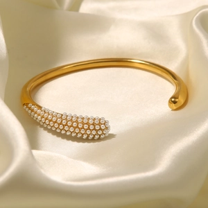 Detailed close-up of a 18K gold-plated open bangle featuring pave-set micro faux pearls