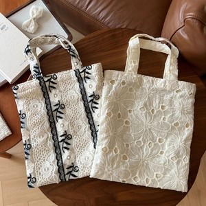Detail of vintage lace tote bags with floral embroidery on a rustic wooden table