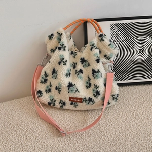 Detail of floral lamb wool tote bag featuring a leather brand tag and colorful handles
