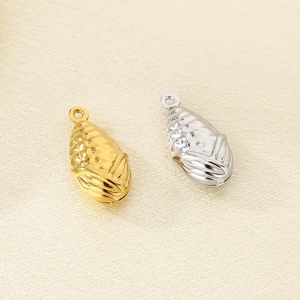 Vue détaillée de pendentifs creux en forme de gland en finitions or et argent