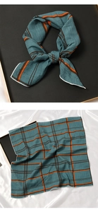 Détail d'un foulard carré en soie à motif à carreaux sarcelle et rayures orange