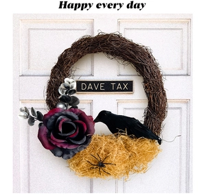 Close-up of Halloween door wreath with black crow, purple rose and spider on white door