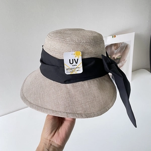 Dettaglio cappello di lino da donna con etichetta anti-UV e fiocco decorativo nero