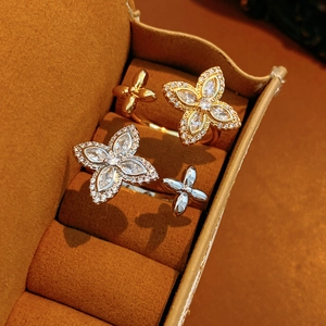Gros plan de bagues trèfles en zircon or et argent dans un coffret à bijoux en velours