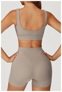 Dettaglio di pantaloncini sportivi a vita alta traspiranti taupe e reggiseno sportivo retro